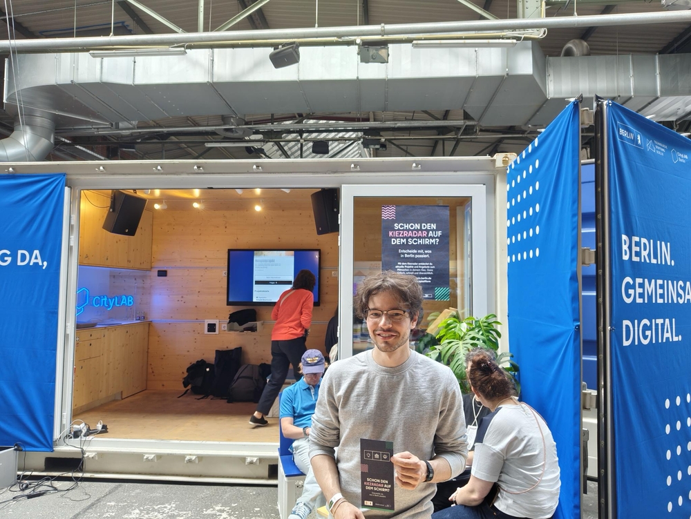 Eine Person steht an einem Messestand.